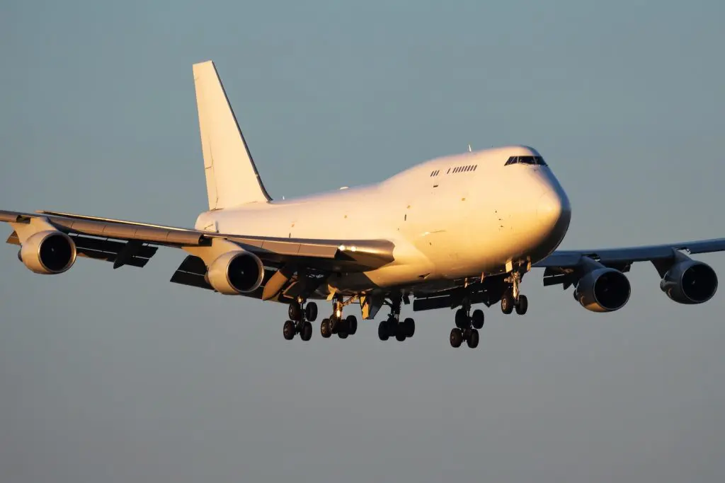 An air cargo plane coming in to land. The businesses using this service compared sea and air freight shipping costs and services to get the best option for their business. They decided the air shipping cost is worth it to get their products delivered quickly.