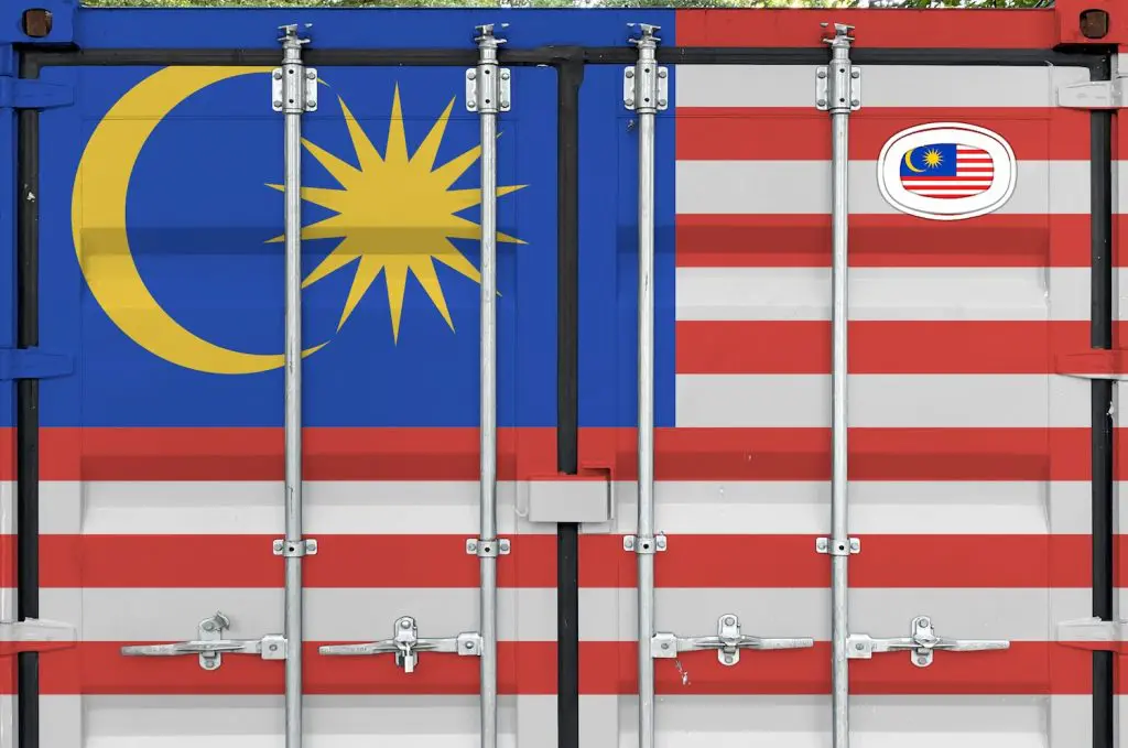 A shipping container with the Malaysian flag on it. This represents how to export from UK to Malaysia.